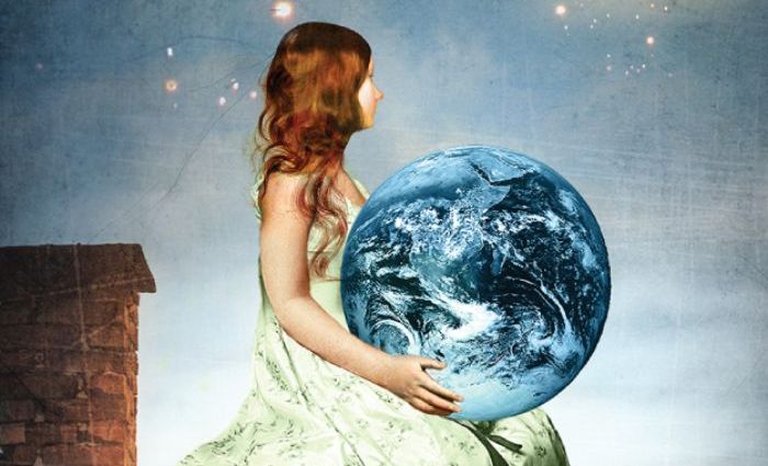 A girl sits on a rooftop and holds the Earth in her hands. (from Tarot of Mystical Moments)